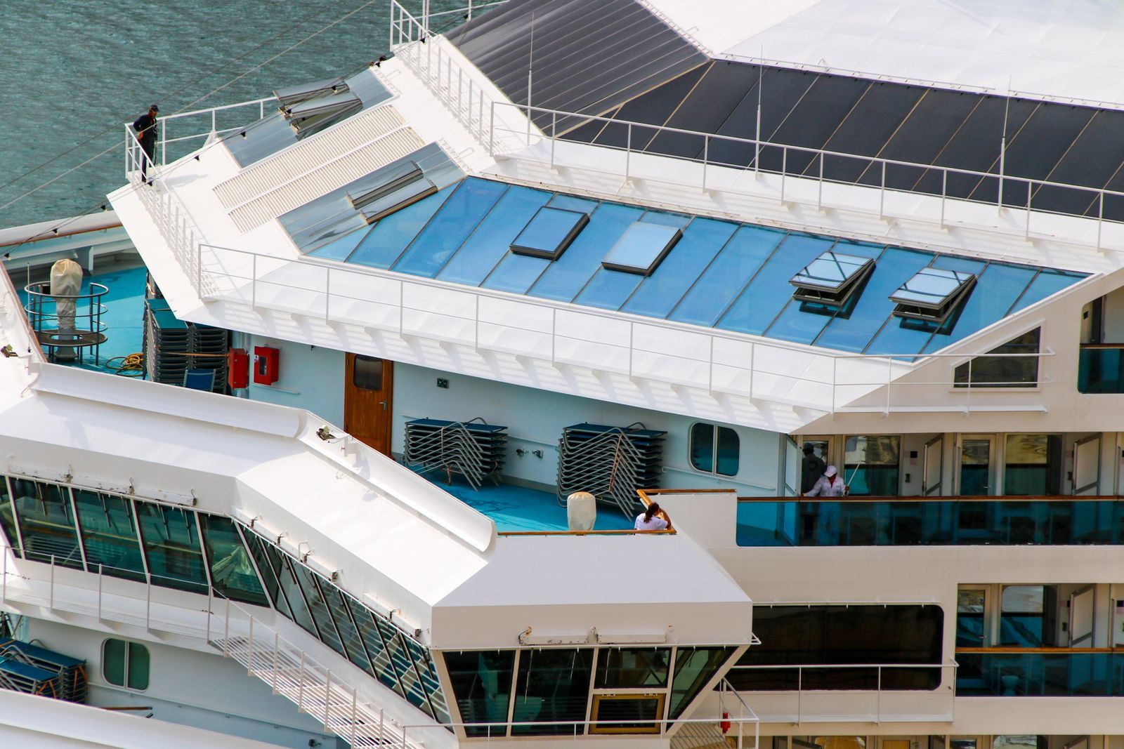 Aerial view of the upper decks of a modern cruise ship with a glass-roofed pool area